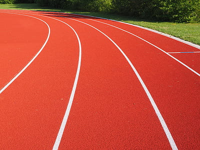 red and white track field during day time thumbnail