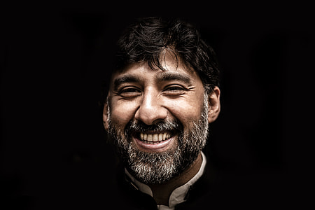 bearded man smiling in dim room thumbnail