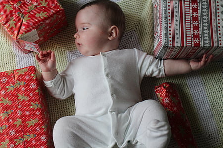 baby lying between gift boxes thumbnail