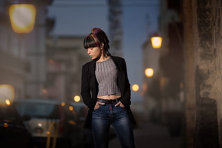 woman wearing blue denim fitted pants standing beside concrete pathway thumbnail