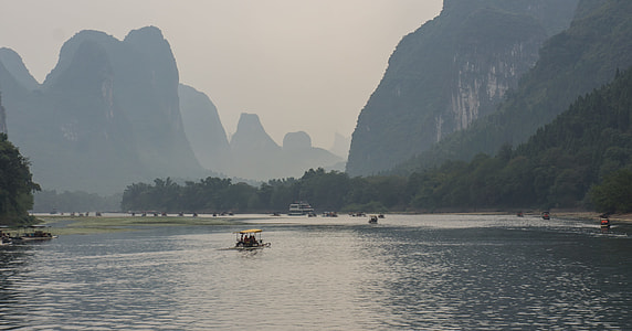 boats on body of water near mountains at daytime thumbnail