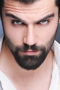 man with black beard in white and gray pinstriped collared top thumbnail
