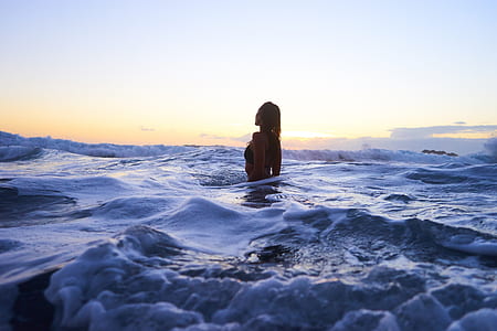 woman in ocean during daytime photography thumbnail
