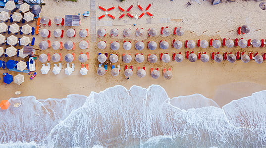 aerial view of patio umbrellas on beach shore thumbnail