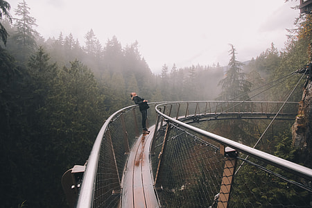 woman leaning on black metal hanging bridge thumbnail