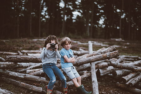 toddlers sitting on log wood outdoor thumbnail