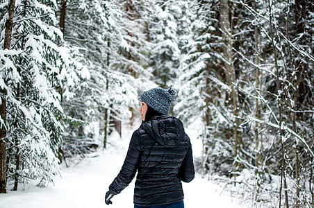 woman standing in middle of snow covered forest thumbnail