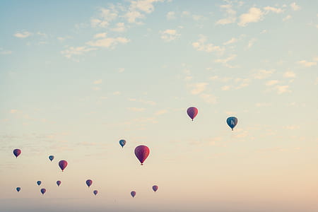 photo of assorted-color hot air balloons under clear blue sky photo taken during sunset thumbnail