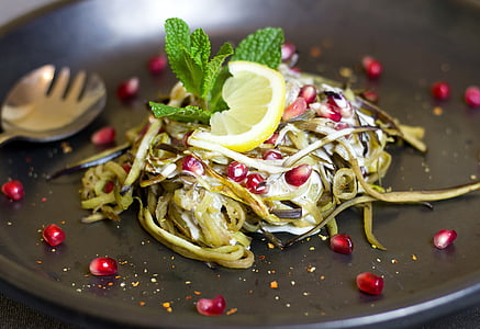 pasta with lime slice and basil placed on black platter thumbnail