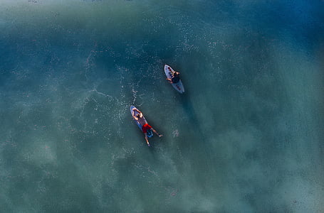 aerial photography of two male riding surfboards thumbnail