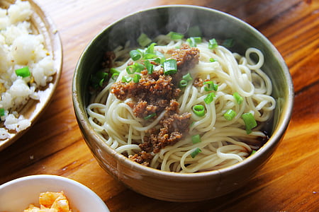 cooked noodle in gray ceramic bowl with spring onions thumbnail