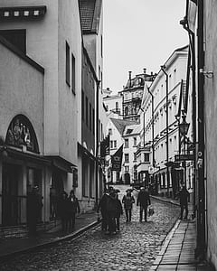 Grayscale Photo of Group of People Walking in Alley thumbnail