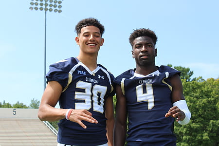 Two Men Wearing American Football Uniform Taking Photo Together thumbnail