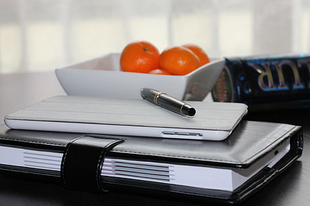 white Android smartphone on top of black leather book binder thumbnail