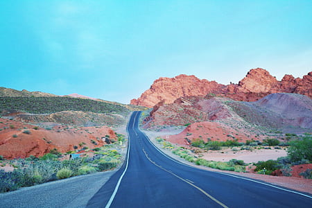 asphalt road surrounded by mountains thumbnail