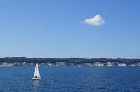 white sailboat on the sea under blue skies thumbnail