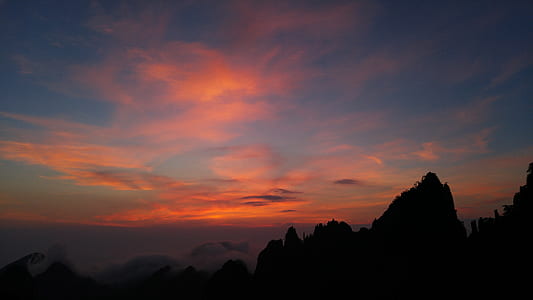 silhouette of mountain under orange and blue sky during sunset thumbnail