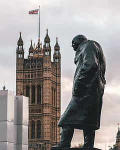 man statue near brown building during daytime thumbnail