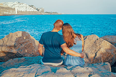 man and woman sitting on rock thumbnail