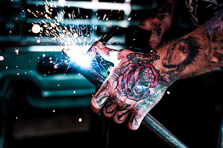 person with tattoos holding tool with light thumbnail