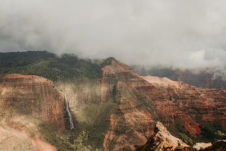 brown and black mountain under cloudy sky during daytime thumbnail