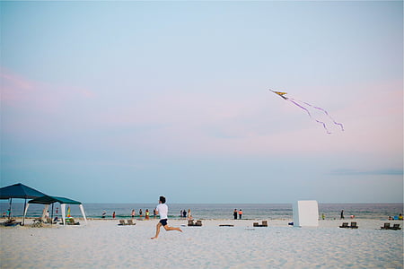 man running on white sand under clear sky thumbnail