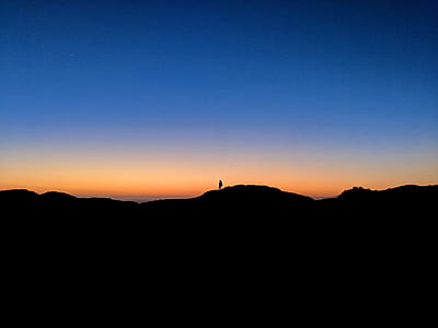 silhouette photography on person on mountain during golden hour thumbnail