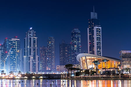 arena near body of water and city buildings during nighttime thumbnail