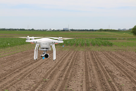 white quadcopter drone flying above brown field at daytime thumbnail