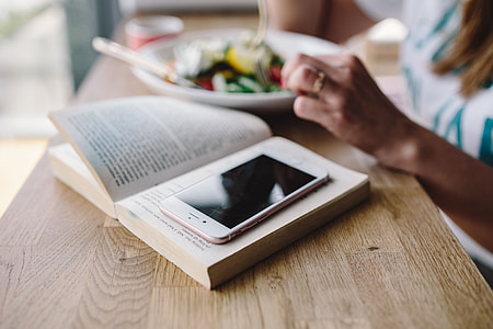 Woman eating breakfast and reading a book thumbnail