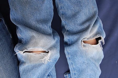 person wearing blue distressed jeans thumbnail