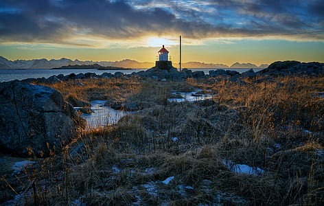 lighthouse at cliff near sea thumbnail