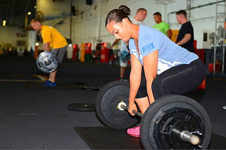 woman in blue t shirt lifting black barbell thumbnail