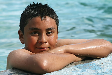 closeup photography of boy leaning on gray tile thumbnail