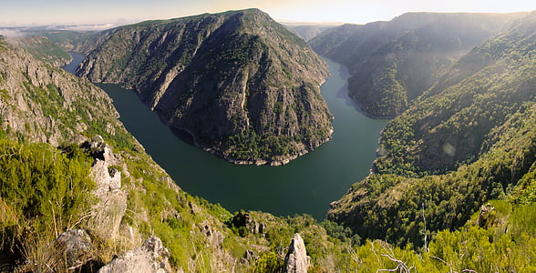 aerial photo of body of water beside mountain during daytime thumbnail