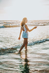woman walking on seaside at daytime thumbnail
