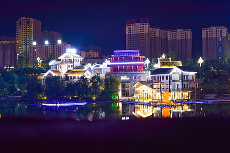 White Concrete House Beside Large Body of Water during Nightime thumbnail