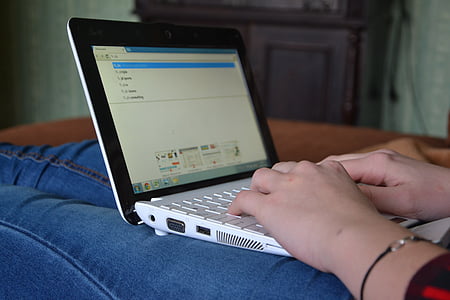 person using laptop while sitting inside room thumbnail