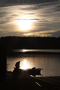 silhouette photo of two men riding on boat during golden hour thumbnail