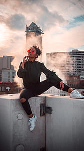 woman sitting on building holding chin thumbnail