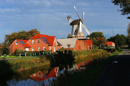 windmill beside river surrounded by trees thumbnail