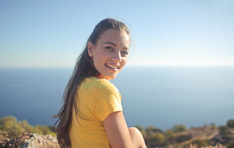 Portrait of Young Woman In Half-Sleeved Yellow Shirt Looking Over Her Shoulder thumbnail