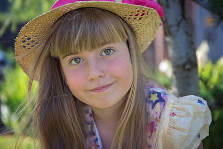 girl wearing brown sun hat smilling thumbnail