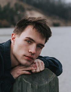 man leaning on brown tree trunk thumbnail