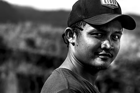 grayscale photography of man wearing shirt and cap thumbnail