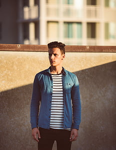 man's standing against wall thumbnail