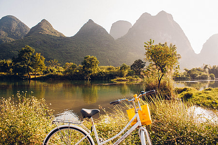 cruiser bicycle near body of water overlooking mountain range thumbnail