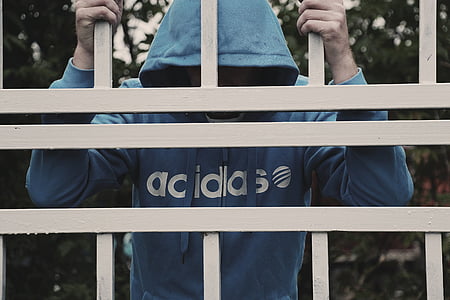 person in blue adidas shirt holding gate bars thumbnail