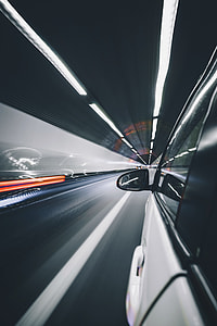 white car travelling in gray tunnel thumbnail