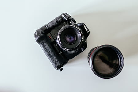 black Canon DSLR camera near extra lens thumbnail